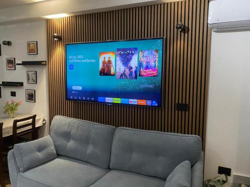a living room with a couch and a flat screen tv at Casa Siculi in Taormina