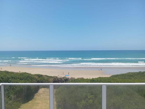 a view of the beach from a balcony of a beach at Seafront! Home in Boggomsbay in Boggomsbaai