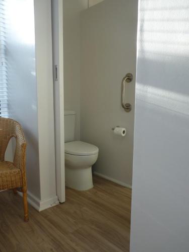 a bathroom with a toilet and a chair at Seafront! Home in Boggomsbay in Boggomsbaai