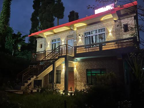 a building with a staircase on the side of it at night at Rise And Shine Homestay in Mirik