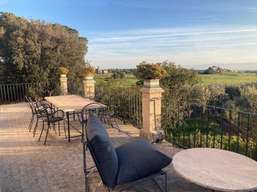 a patio with tables and chairs and a fence at Villa Quartarella - La bellezza nel silenzio - piscina in Michelica