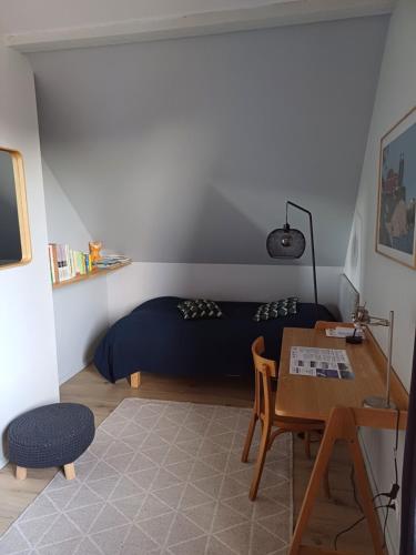 a bedroom with a bed and a desk and a table at CHARMANT APPARTEMENT à 150 M des THERMES et du CENTRE VILLE in Thonon-les-Bains