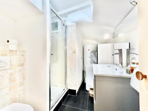 une salle de bain blanche avec une douche et un lavabo dans l'établissement Èrsextius, NP, Aix-en-Provence, à Aix-en-Provence