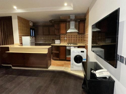 a kitchen with a washer and dryer in it at ايوان التميز للشقق الفندقية- Ewan Altamayoz Hotel Apartment in Tabuk