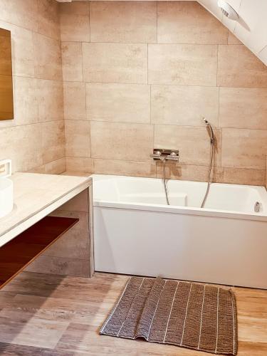 une salle de bain avec une baignoire blanche et un lavabo dans l'établissement Chez Madeleine, Entre le Lioran et Vic-sur-Cère, à Thiézac