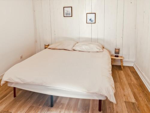 ein großes weißes Bett in einem Zimmer mit Holzboden in der Unterkunft Chez Madeleine, Entre le Lioran et Vic-sur-Cère in Thiézac