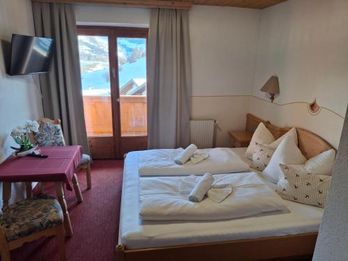 a hotel room with two beds and a window at Pension Razil in Ladis