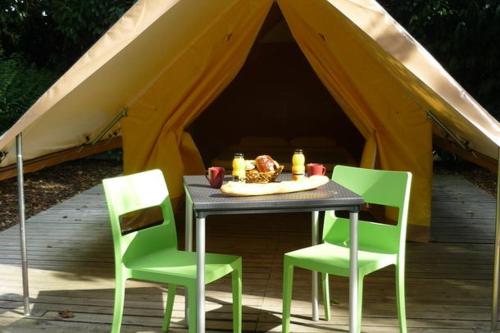 a table with four chairs and a tent at Camping Onlycamp de Boucocers in Lagrasse
