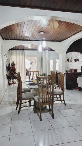 a dining room with a table and chairs and a christmas tree at Casa Luxo Ampla Completa COP30 in Ananindeua