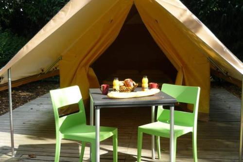 une table et quatre chaises dans une tente dans l'établissement Camping Onlycamp de Boucocers, à Lagrasse