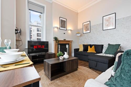 a living room with a couch and a tv at Modern 2 Bedroom Abode - Sea Views - Balcony in Worthing