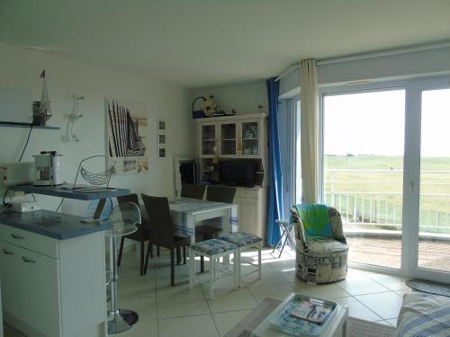 une cuisine et un salon avec une table et des chaises dans l'établissement Le Pamplemousse, à Saint-Jean-de-Monts