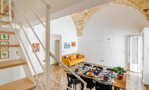 a living room with a table and a staircase at La casa dell' artista in Ugento
