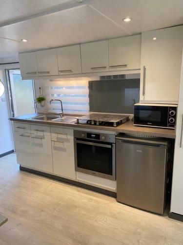 a kitchen with a sink and a stove top oven at Bungalow cosy varois avec piscine soleil calme et nature in Pourrières