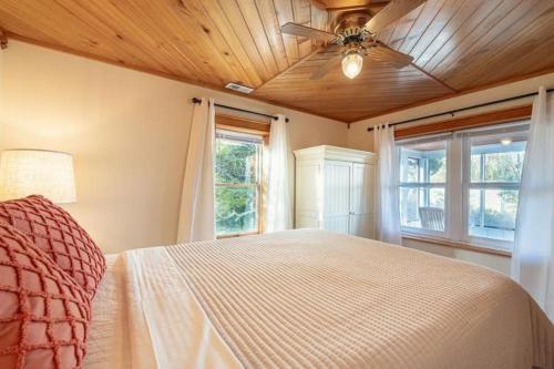 a bedroom with a bed with a ceiling fan and windows at Vitamin Beach 12 in Avon
