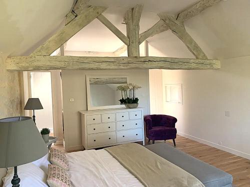 a bedroom with a bed and a dresser with a mirror at Domaine de Monciaux 2 piscines Tennis 40 Pers in Bourrou