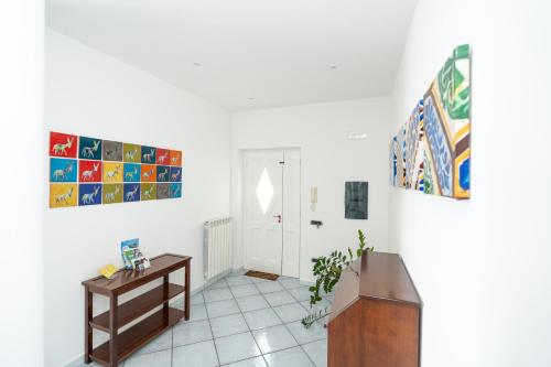 a white room with a table and paintings on the wall at Residenza Sant'Angelo - Art Apartment in Minori