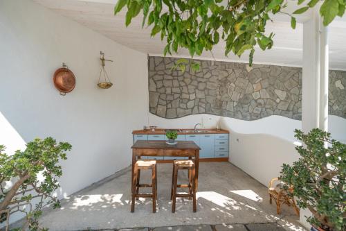 a kitchen with a wooden table and two stools at Residenza Sant'Angelo - Art Apartment in Minori