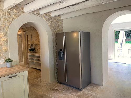 a kitchen with a stainless steel refrigerator in a room at Domaine de Monciaux 2 piscines Tennis 40 Pers in Bourrou