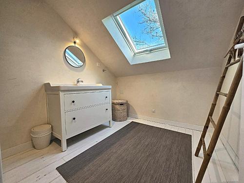 a bathroom with a sink and a skylight at Domaine de Monciaux 2 piscines Tennis 40 Pers in Bourrou