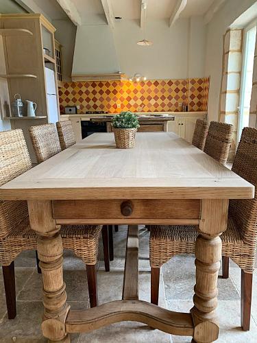 a wooden table in a kitchen with chairs at Domaine de Monciaux 2 piscines Tennis 40 Pers in Bourrou