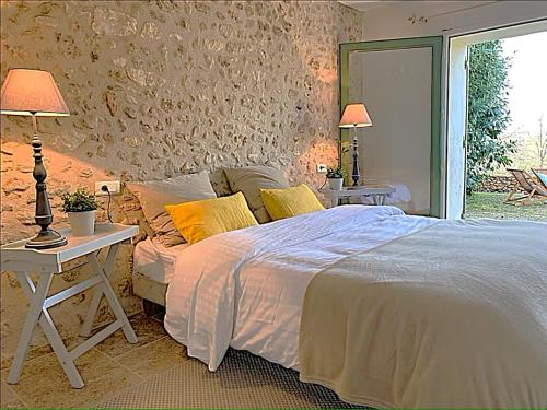 a bedroom with a bed and a table with lamps at Domaine de Monciaux 2 piscines Tennis 40 Pers in Bourrou