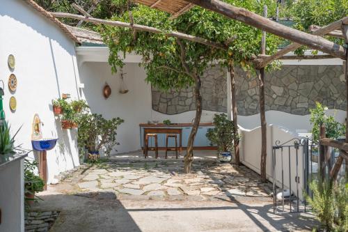 a courtyard in a house with a table and a tree at Residenza Sant'Angelo - Art Apartment in Minori