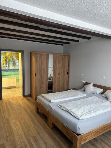 a bedroom with a large bed with a wooden ceiling at Ferienwohnungen Büffel in Heimbach