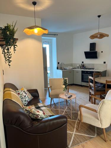 un salon avec un canapé en cuir et une table dans l'établissement Appartement face au château, à Murol