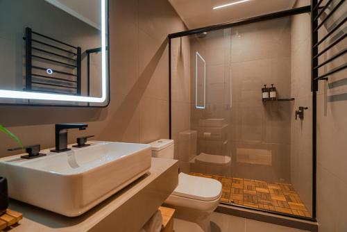 a bathroom with a sink and a toilet and a shower at Mater Hotel in Canela