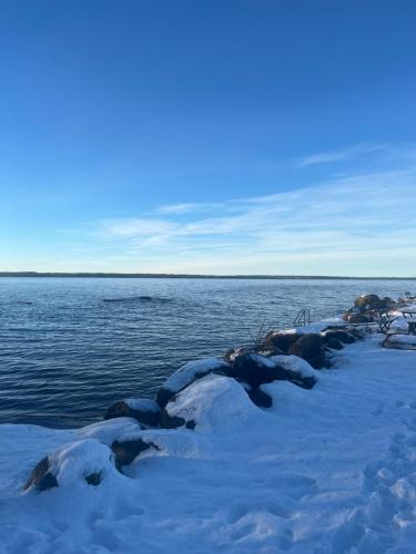 a group of rocks in the snow next to the water at Boende Sannerud Tived in Tived