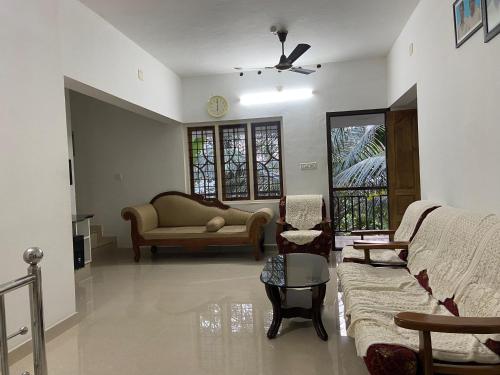 a living room with a couch and chairs and a table at The Lovely Home Stay in Munnar