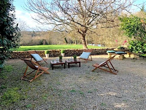 a group of chairs and a picnic table in a yard at Domaine de Monciaux 2 piscines Tennis 40 Pers in Bourrou
