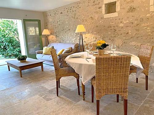a living room with a table and chairs and a couch at Domaine de Monciaux 2 piscines Tennis 40 Pers in Bourrou