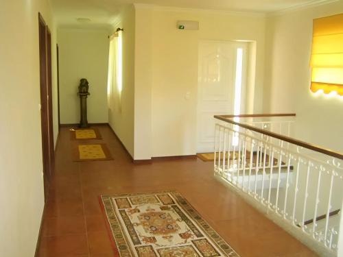 a hallway with a staircase with a rug on the floor at Casa Tadeu in Anjos