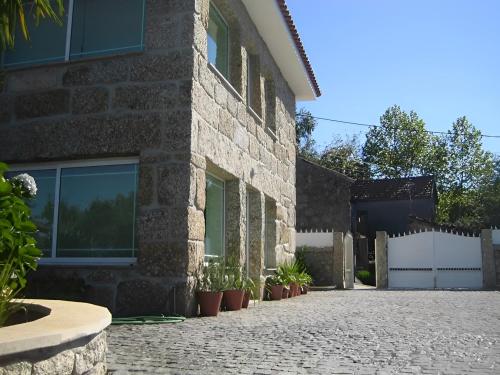a brick building with potted plants on a driveway at Casa Tadeu in Anjos