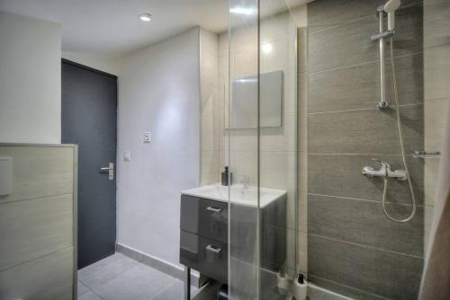 une salle de bain avec une douche en verre avec un lavabo dans l'établissement Le 8 - Cannes, à Cannes