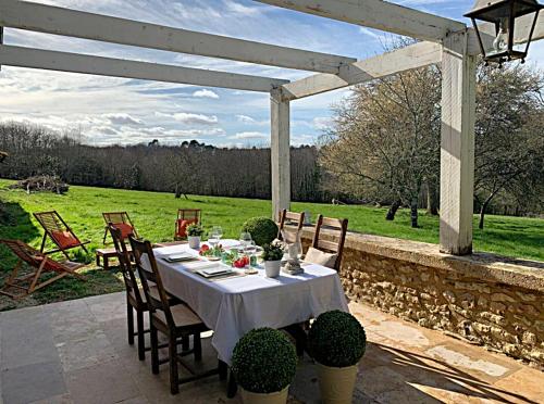 a table with a white table cloth on a patio at Domaine de Monciaux 2 piscines Tennis 40 Pers in Bourrou