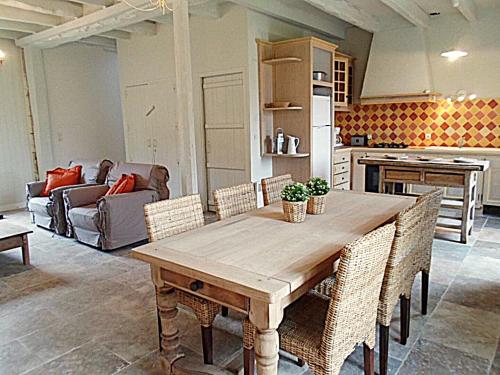 a kitchen with a wooden table and some chairs at Domaine de Monciaux 2 piscines Tennis 40 Pers in Bourrou