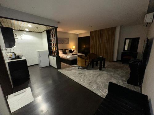a hotel room with a bed and a living room at ايوان التميز للشقق الفندقية- Ewan Altamayoz Hotel Apartment in Tabuk