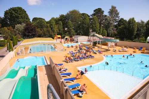 une grande piscine avec des personnes assises dans l'eau dans l'établissement Appartements Benodet à 300m de la mer, à Bénodet