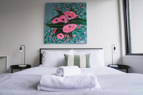 a bedroom with a bed with towels on it at Spacious Richmond Home - Walk to MCG, Venues & CBD in Melbourne