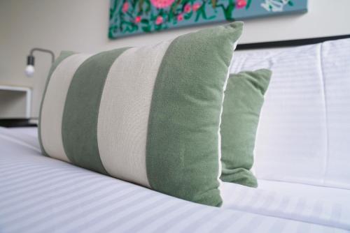 a bed with green and white pillows on it at Spacious Richmond Home - Walk to MCG, Venues & CBD in Melbourne