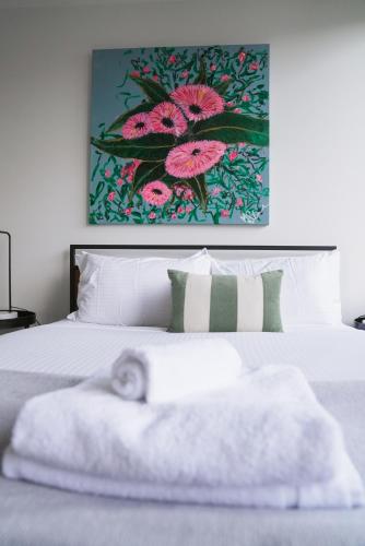 a bedroom with a bed with a painting on the wall at Spacious Richmond Home - Walk to MCG, Venues & CBD in Melbourne