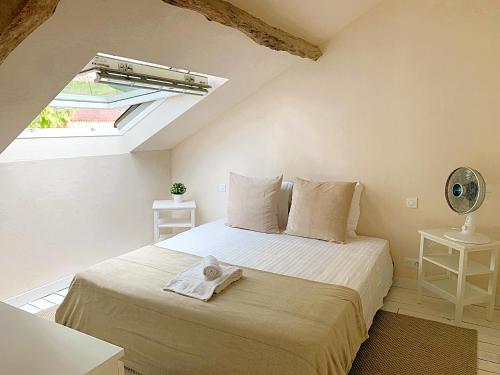 a bedroom with a bed in a room with a window at Domaine de Monciaux 2 piscines Tennis 40 Pers in Bourrou