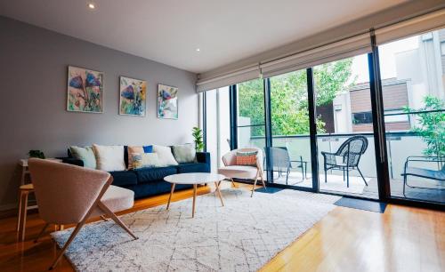 a living room with a couch and a table and chairs at Spacious Richmond Home - Walk to MCG, Venues & CBD in Melbourne