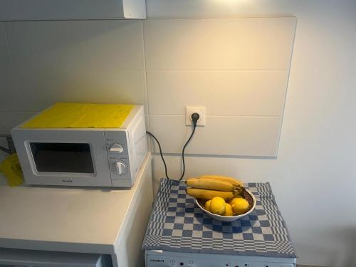 - un bol de bananes et de citrons à côté d'un four micro-ondes dans l'établissement Studio cosy, à 2 pas RER A et E, à Le Perreux-Sur-Marne