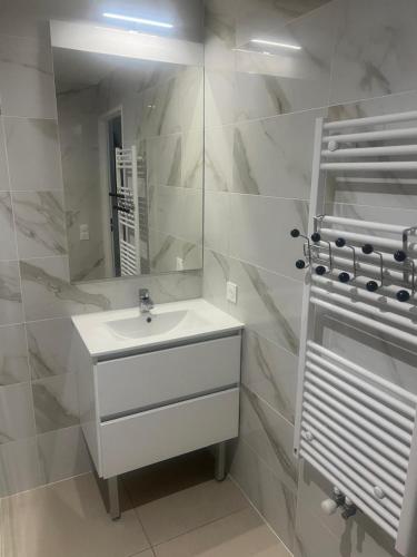 une salle de bain blanche avec un lavabo et un miroir dans l'établissement Studio cosy, à 2 pas RER A et E, à Le Perreux-Sur-Marne