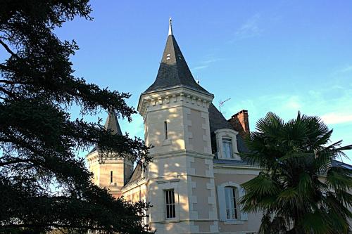 a building with a tower with a clock on it at Domaine de Monciaux 2 piscines Tennis 40 Pers in Bourrou
