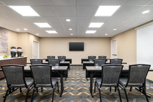 a conference room with tables and chairs and a screen at Residence Inn by Marriott Mechanicsburg in Enola